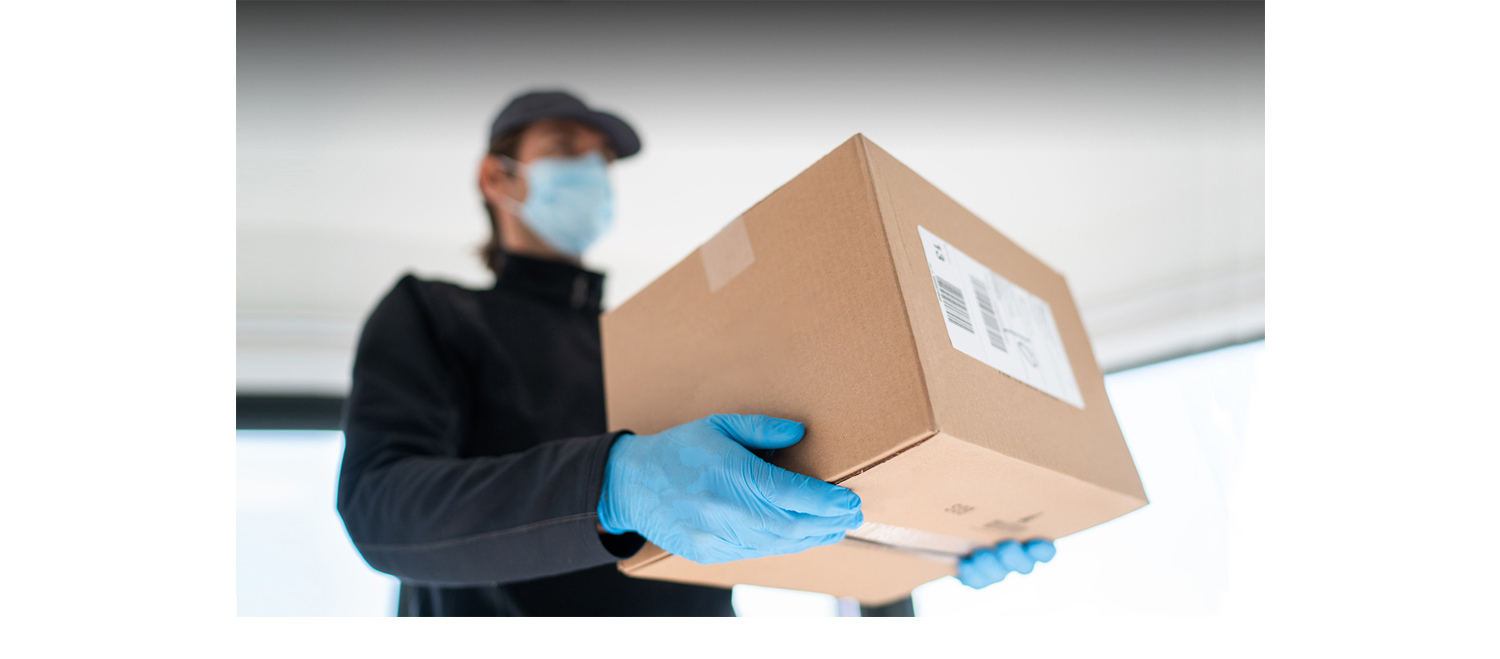 Delivery worker wearing a PPE mask and gloves delivers a package.